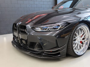 Schwarzes Auto mit dynamischer Front und auffälligen Felgen.