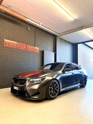 Sportliches Auto in Garage mit Neonschriftzug