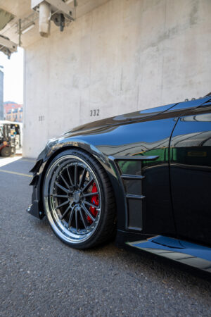 Sportwagenreifen mit roten Bremssätteln auf Asphalt