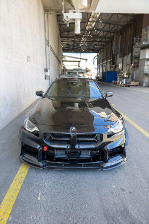 Schwarzes Auto in Lagerhalle geparkt.