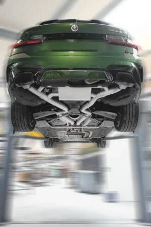 Grünes Auto auf einer Hebebühne von unten.