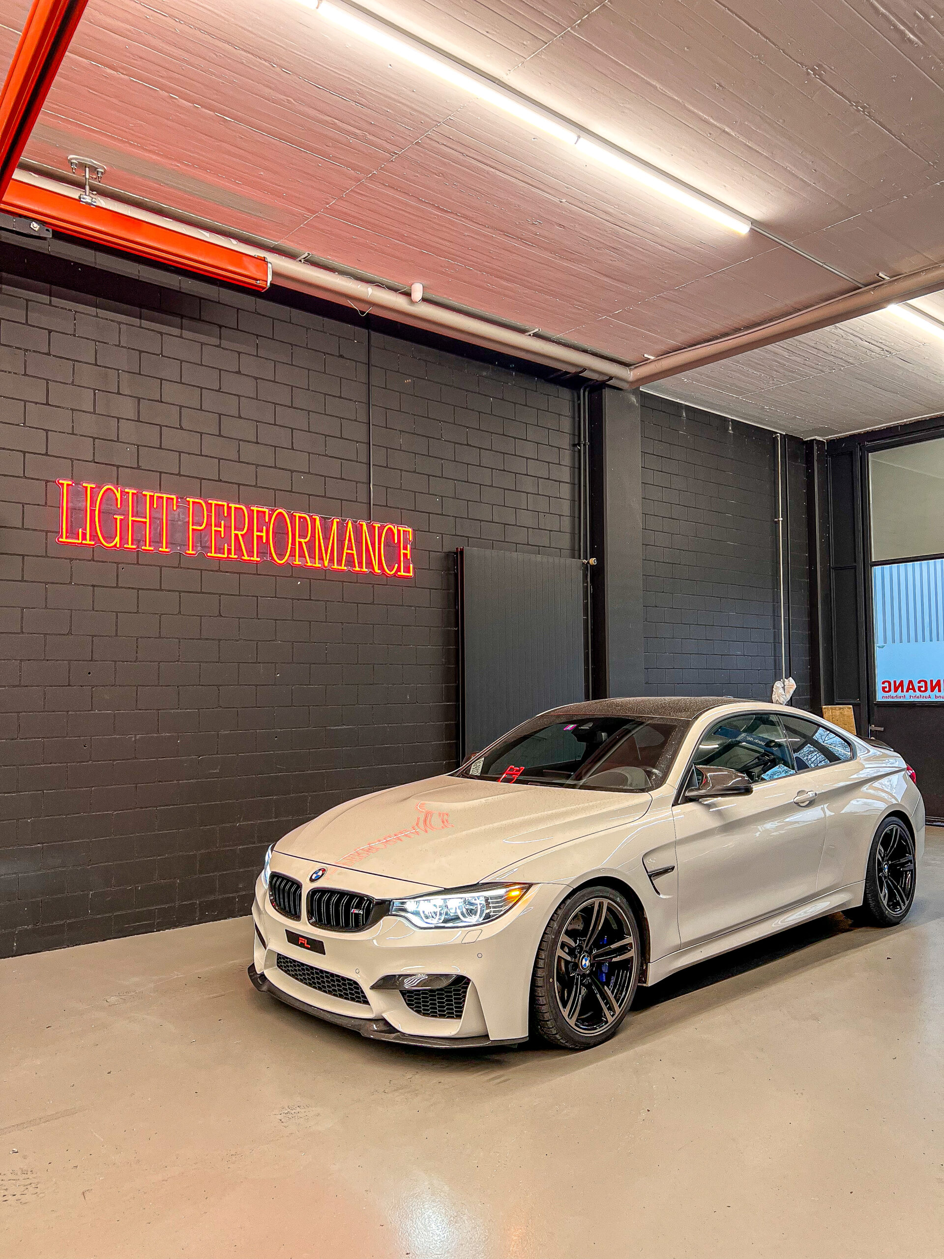 Weißes Auto in Garage mit Neonlicht