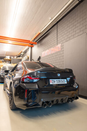 Schwarzes Auto in einer Werkstatt, Rückansicht